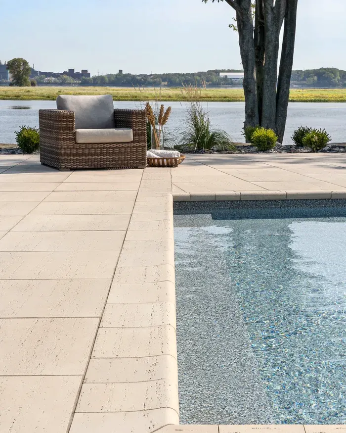 an outdoor chair sitting on a patio near a pool
