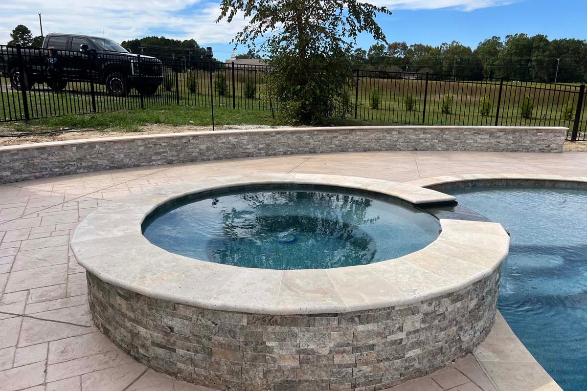 a circular spa with waterfall into a pool