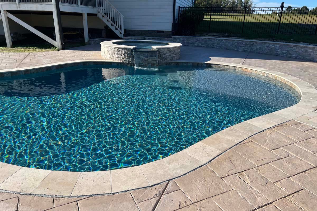 a freeform pool in the backyard patio of a home
