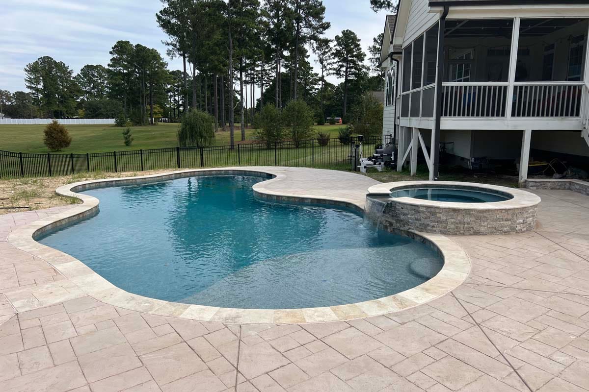 a freeform pool in the backyard patio of a home