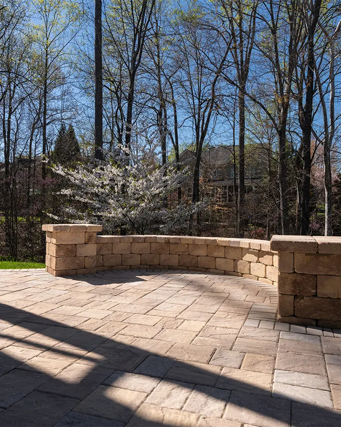 a stone patio with a curved wall