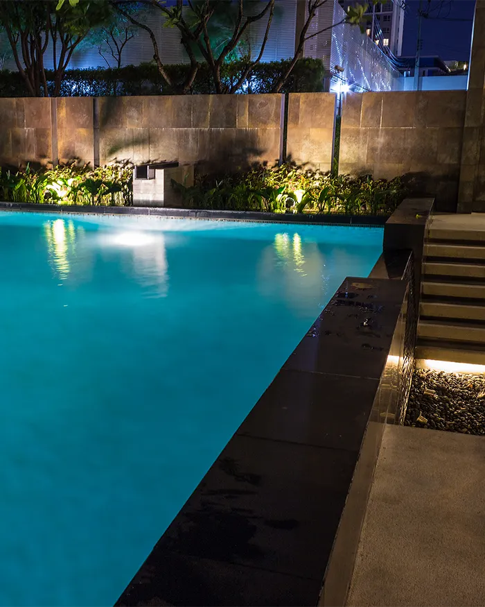 a rectangular pool in the backyard patio of a home