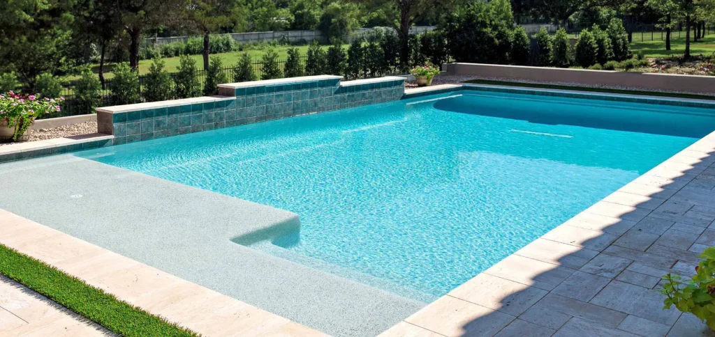 a rectangular pool in the backyard patio of a home