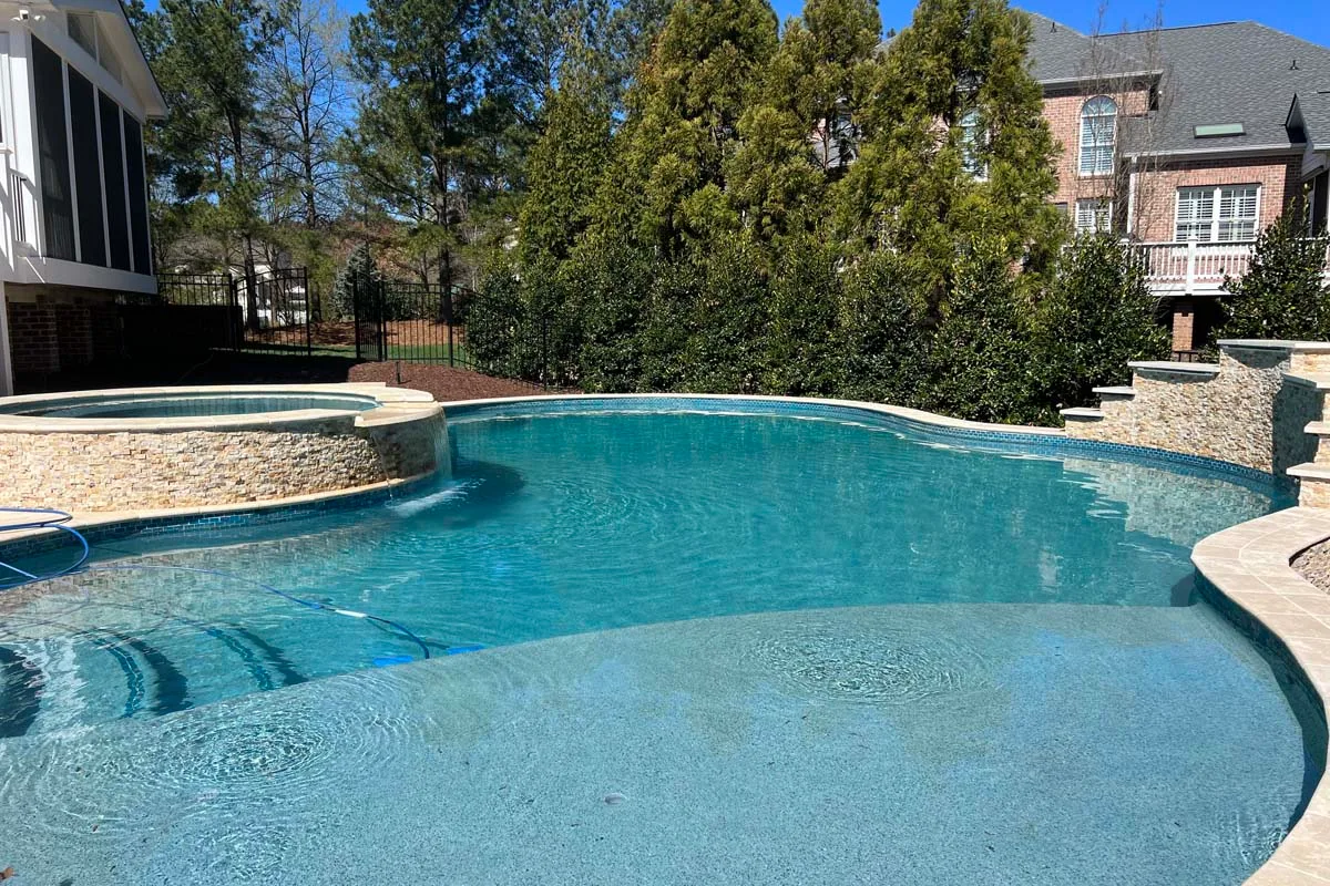 a freeform pool in the backyard patio of a home