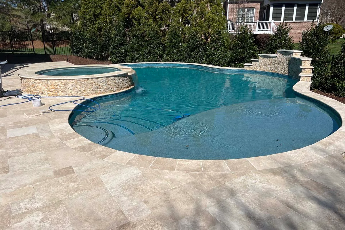 a freeform pool in the backyard patio of a home