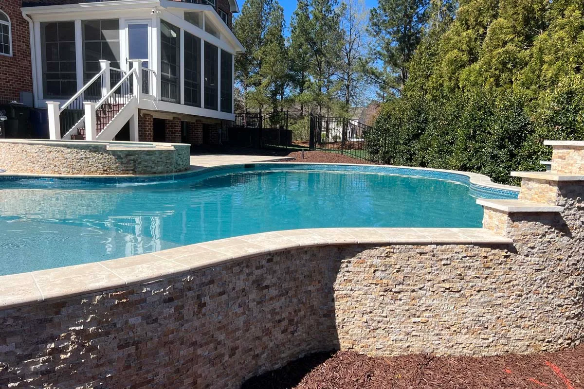 a freeform pool in the backyard patio of a home